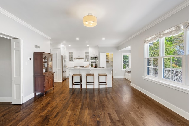 kitchen featuring crown molding, appliances with stainless steel finishes, decorative backsplash, and dark wood-style floors