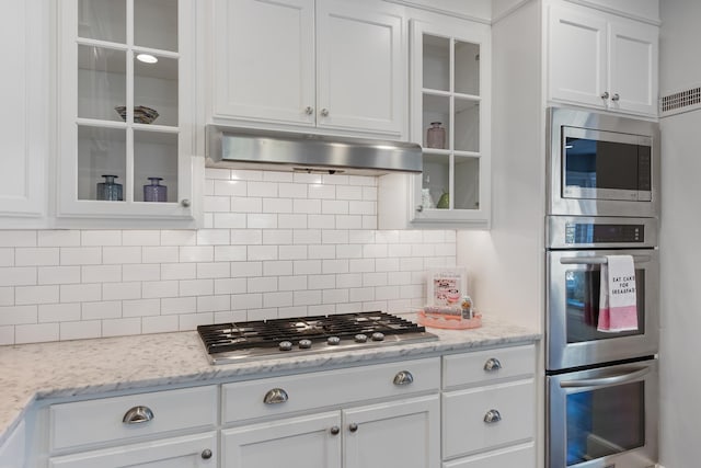 kitchen featuring white cabinetry, stainless steel appliances, and under cabinet range hood
