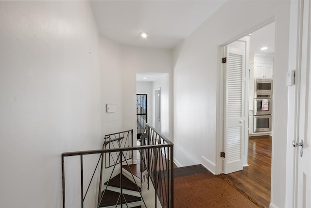 hallway featuring recessed lighting, an upstairs landing, wood finished floors, and baseboards