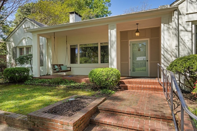 entrance to property with a chimney and covered porch