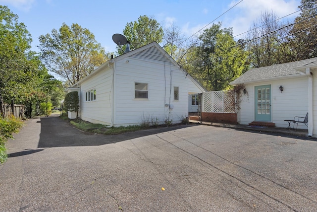 view of side of property featuring entry steps and aphalt driveway