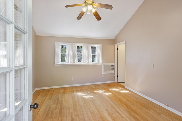 empty room featuring ceiling fan, vaulted ceiling, wood finished floors, an AC wall unit, and baseboards
