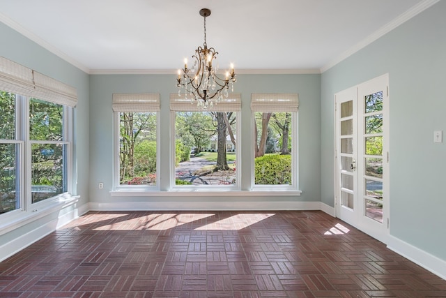 unfurnished dining area with a chandelier, baseboards, and ornamental molding