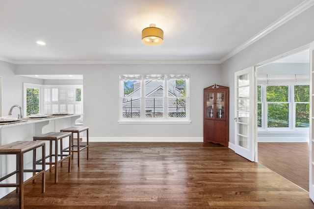 dining area featuring crown molding, baseboards, dark wood finished floors, and recessed lighting