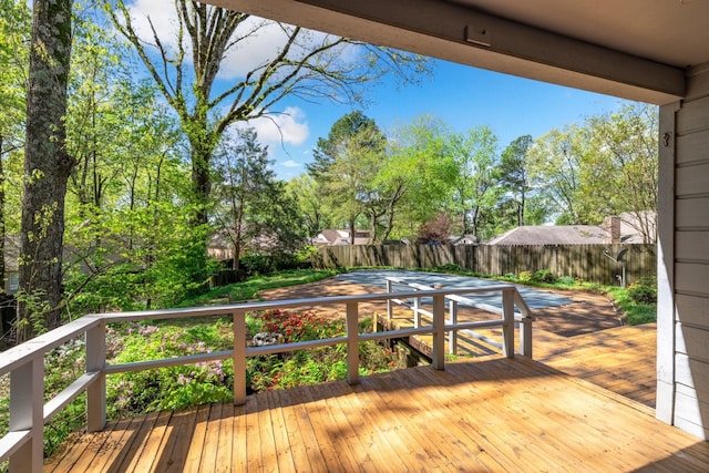 wooden terrace with a fenced backyard