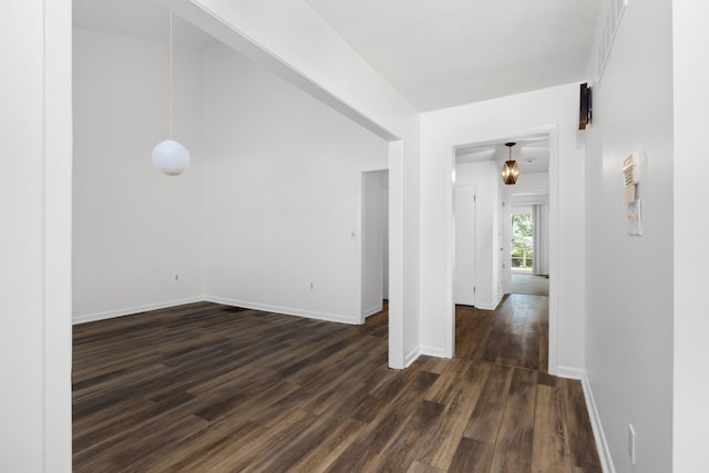 empty room featuring dark wood finished floors and baseboards