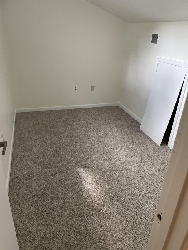 unfurnished room featuring carpet floors and baseboards
