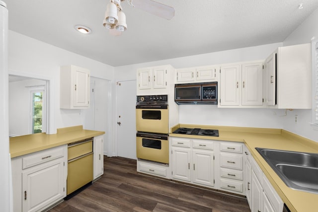 kitchen with black appliances, white cabinets, dark wood finished floors, and light countertops