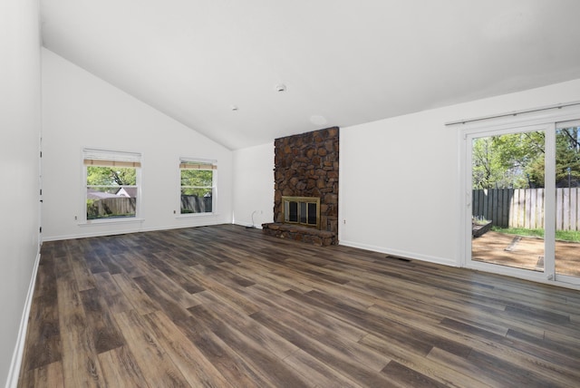 unfurnished living room with high vaulted ceiling, plenty of natural light, dark wood-style floors, and a stone fireplace