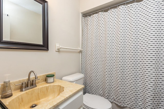bathroom featuring curtained shower, vanity, and toilet