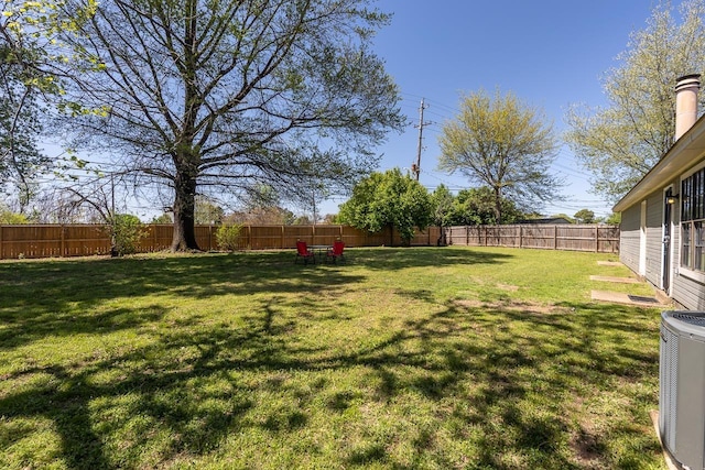 view of yard with central AC unit and a fenced backyard
