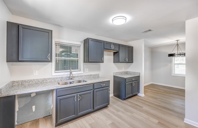 3191 Scenic Hwy, Memphis, TN 38128 - kitchen with visible vents, baseboards, a sink, light stone countertops, and light wood-style flooring