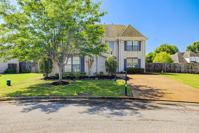 traditional home featuring a front yard and fence