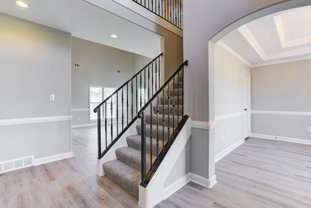 staircase with recessed lighting, arched walkways, visible vents, and wood finished floors