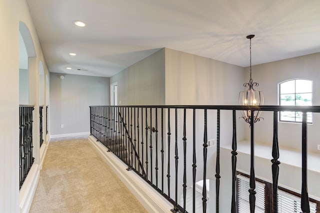 corridor featuring recessed lighting, a notable chandelier, baseboards, and carpet floors
