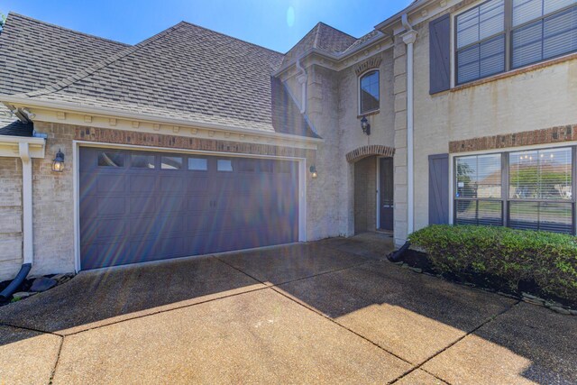 view of front of home with an attached garage, a shingled roof, stucco siding, and concrete driveway