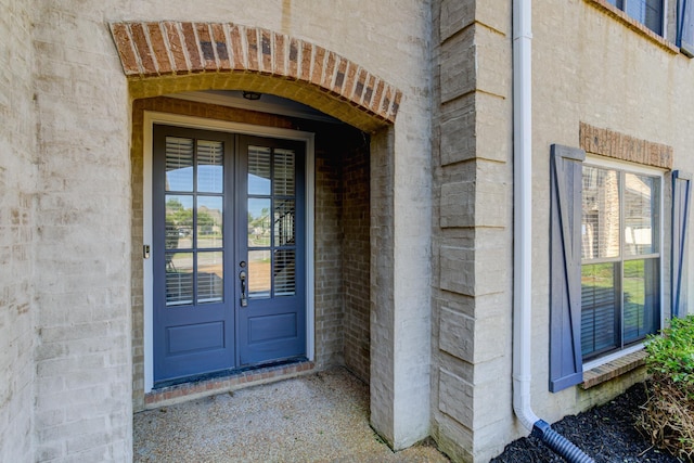 entrance to property featuring brick siding and french doors