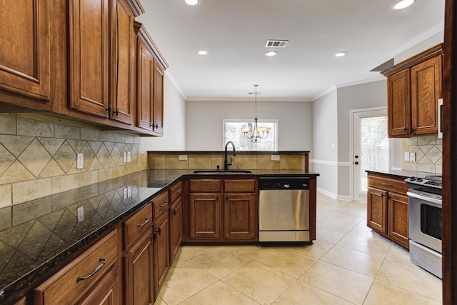 kitchen with an inviting chandelier, a peninsula, a sink, stainless steel appliances, and decorative backsplash