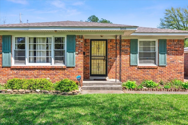 view of front facade with a front yard and brick siding