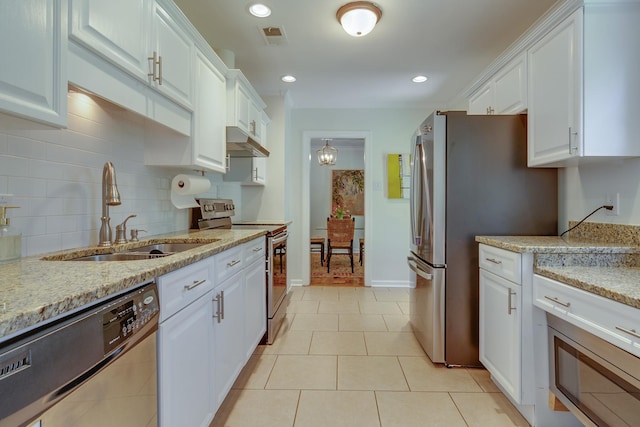 kitchen featuring a sink, stainless steel appliances, white cabinetry, backsplash, and under cabinet range hood