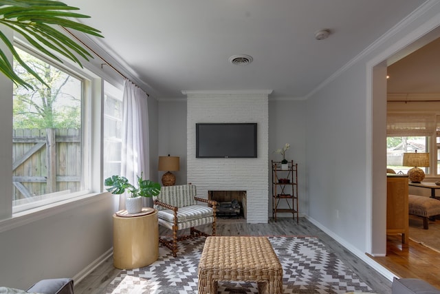 sitting room with a fireplace, crown molding, baseboards, and visible vents
