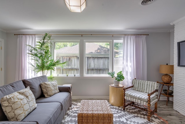 living room featuring crown molding, visible vents, wood finished floors, and baseboards