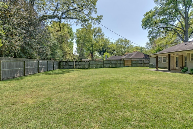 view of yard featuring a fenced backyard, ceiling fan, a patio area, and central AC