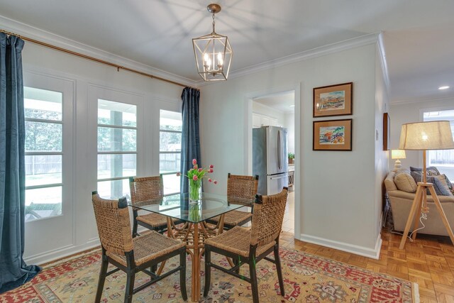 dining space with a chandelier, baseboards, and ornamental molding