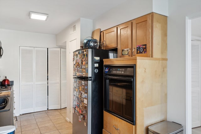 433 S Perkins Dr Unit 433, Memphis, TN 38117 - kitchen featuring light tile patterned floors, visible vents, freestanding refrigerator, and black oven