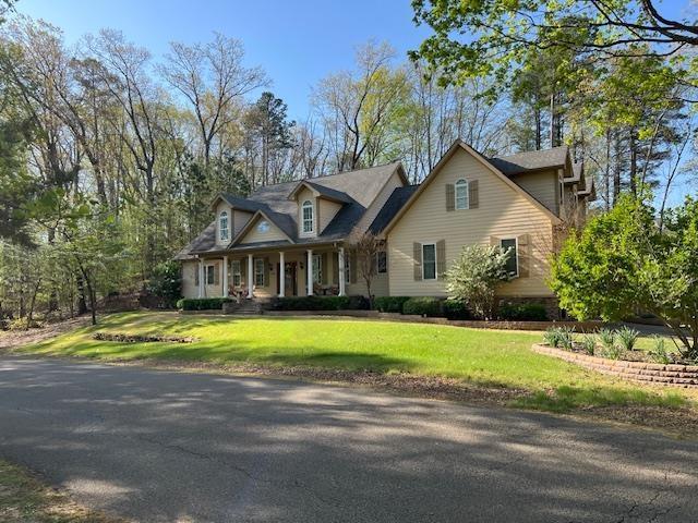 cape cod house featuring a front lawn and covered porch