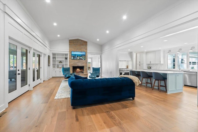 6555 Oak Estates Dr, Memphis, TN 38119 - living room with light wood-style floors, a stone fireplace, vaulted ceiling, and plenty of natural light