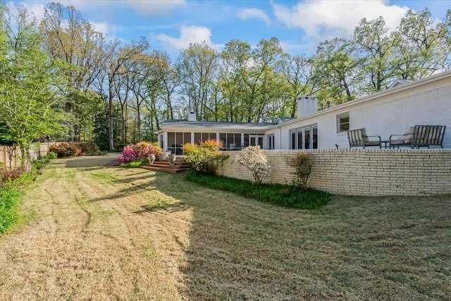 6555 Oak Estates Dr, Memphis, TN 38119 - back of house featuring fence, a yard, a sunroom, and a chimney