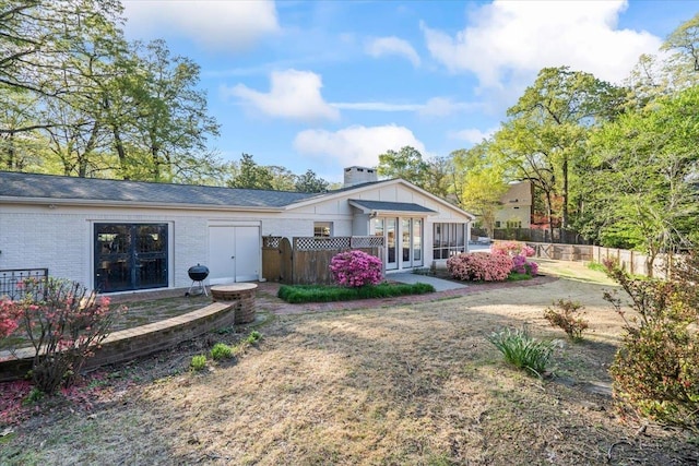 6555 Oak Estates Dr, Memphis, TN 38119 - back of property with french doors, brick siding, fence, and a chimney