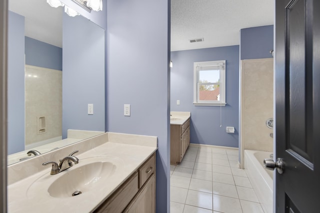 979 Welbeck Cv, Collierville, TN 38017 - bathroom featuring two vanities, a textured ceiling, visible vents, a sink, and tile patterned floors
