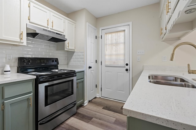 1098 Capital Ave, Memphis, TN 38107 - kitchen with white cabinetry, under cabinet range hood, stainless steel electric stove, a sink, and wood finished floors