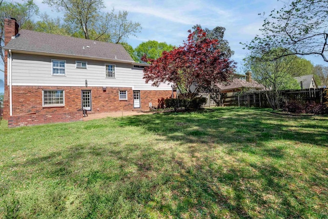 7545 Wheatley Dr, Germantown, TN 38138 - back of house with a yard, fence, brick siding, and a chimney