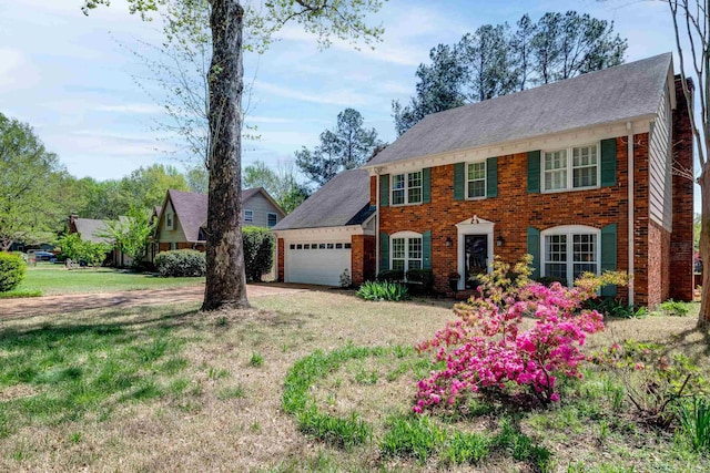 7545 Wheatley Dr, Germantown, TN 38138 - colonial house with an attached garage, brick siding, a front lawn, and dirt driveway