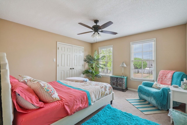 bedroom featuring baseboards, a closet, a textured ceiling, a ceiling fan, and carpet