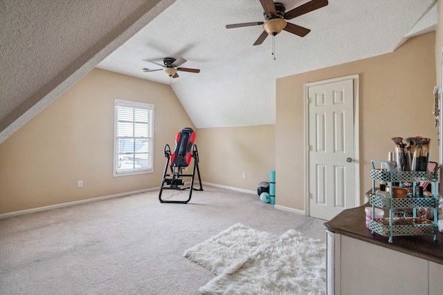 recreation room featuring ceiling fan, light colored carpet, baseboards, and a textured ceiling