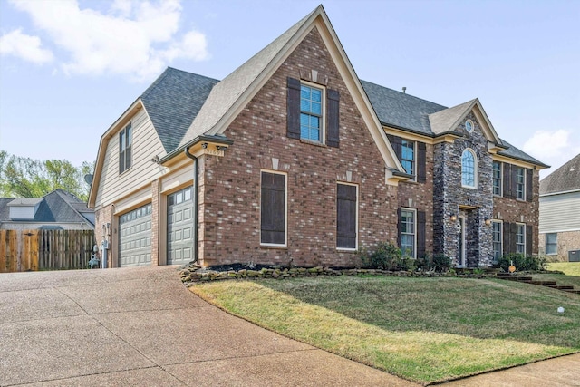 view of front of home with a garage, fence, concrete driveway, brick siding, and a front lawn