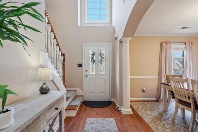 entryway featuring ornate columns, visible vents, stairway, wood finished floors, and baseboards
