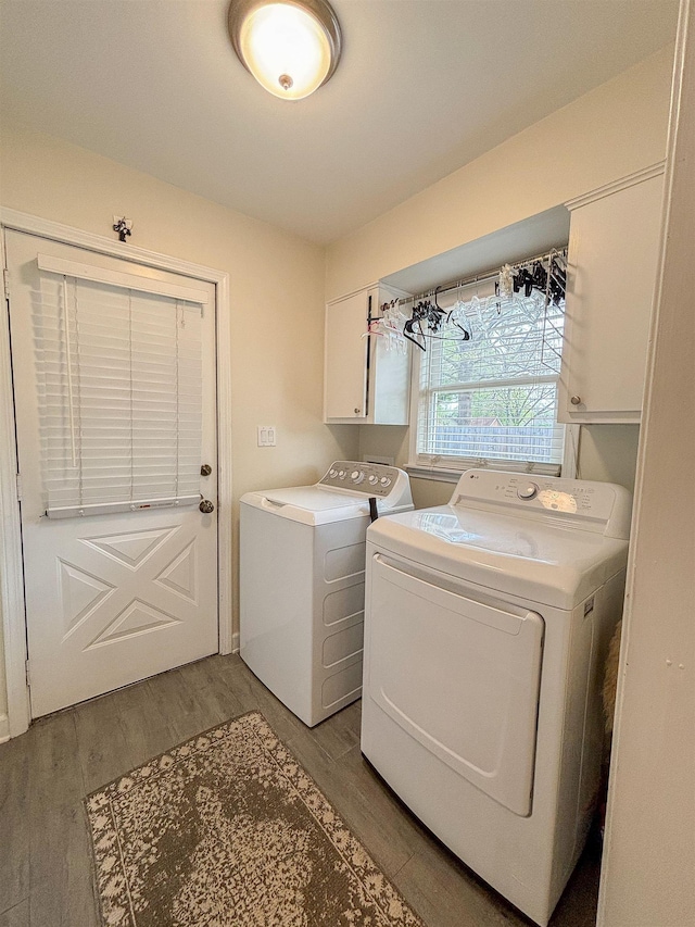 laundry room with cabinet space, washing machine and clothes dryer, and light wood-style flooring