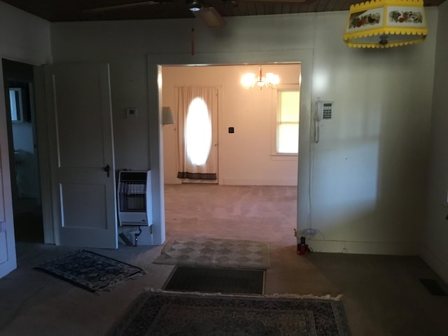 carpeted entryway with ceiling fan with notable chandelier, visible vents, and heating unit