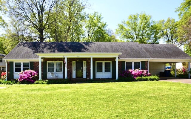 single story home featuring an attached carport, brick siding, concrete driveway, and a front lawn