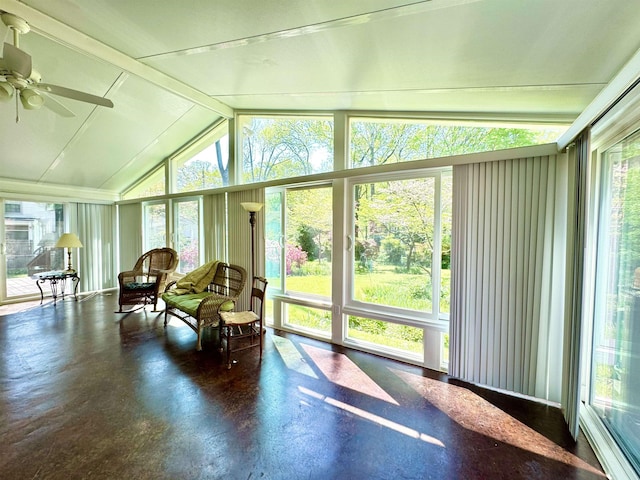 sunroom / solarium featuring vaulted ceiling with beams, ceiling fan, and concrete flooring