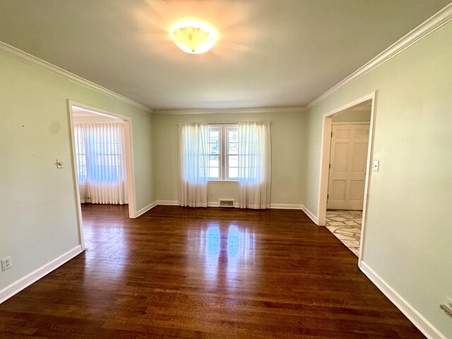 empty room with baseboards, ornamental molding, and wood finished floors