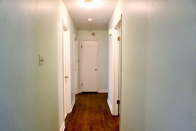 hallway with baseboards and wood finished floors