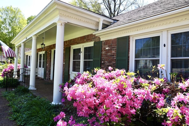 view of property exterior with covered porch and brick siding