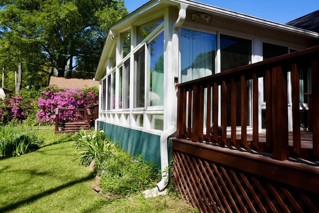 view of side of home featuring a lawn and a wooden deck