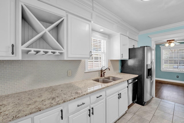 kitchen featuring appliances with stainless steel finishes, crown molding, white cabinets, ceiling fan, and a sink